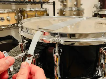 attaching snare strap to drum